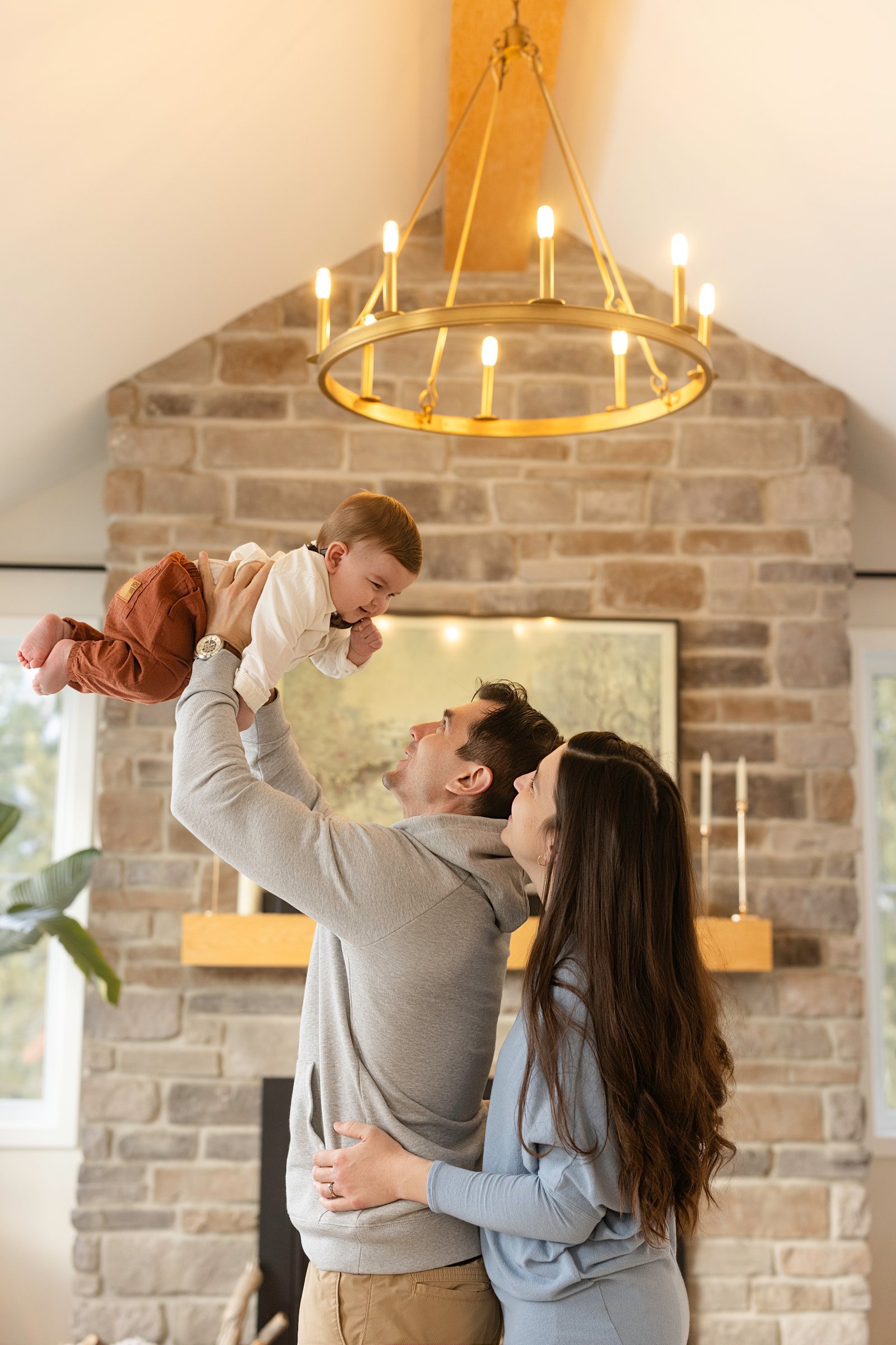 Parents jouant avec leur bébé dans une maison lumineuse