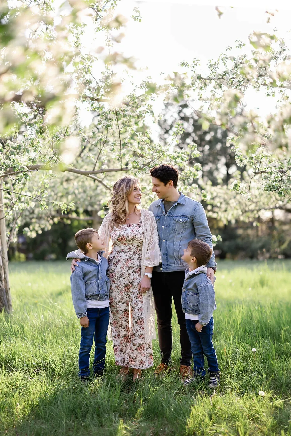 Famille de quatre réunie sous un pommier en fleurs