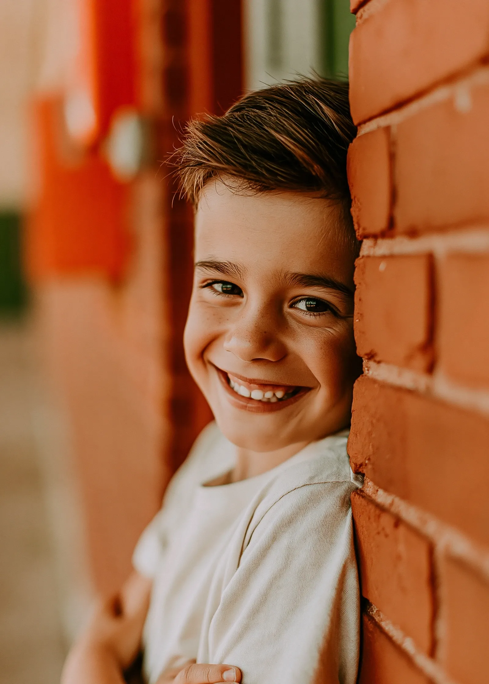 Portrait spontané d’un garçon appuyé sur le mur de brique de son école